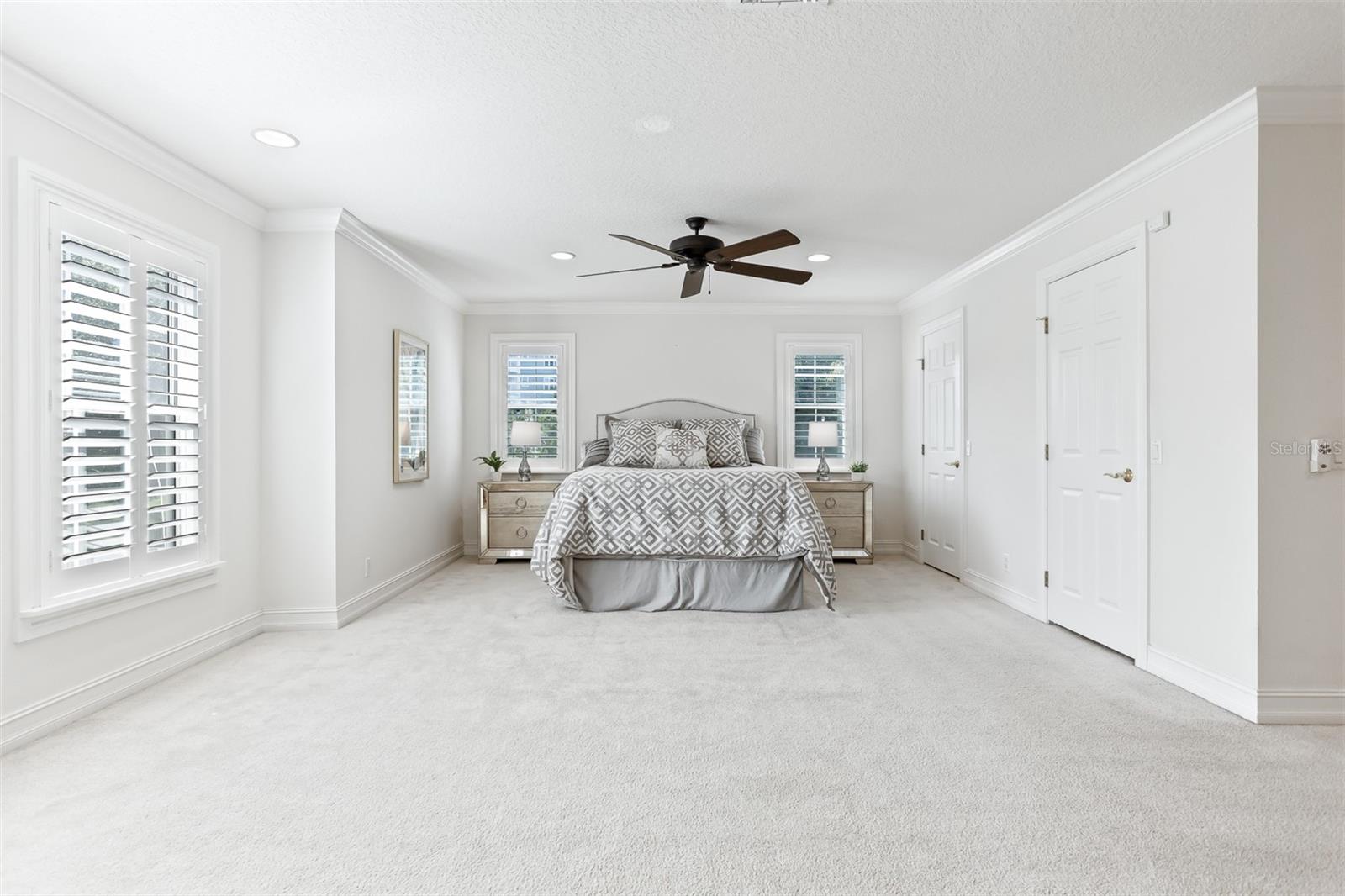 Large Primary Suite with two walk in closets customized by California Closets, custom shutters and  lots of space