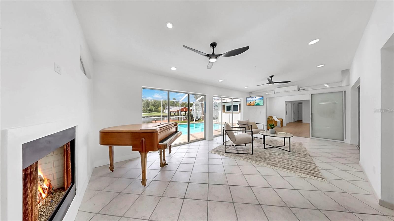Florida room w/ AC Split and fireplace overlooking pool and waterfront.