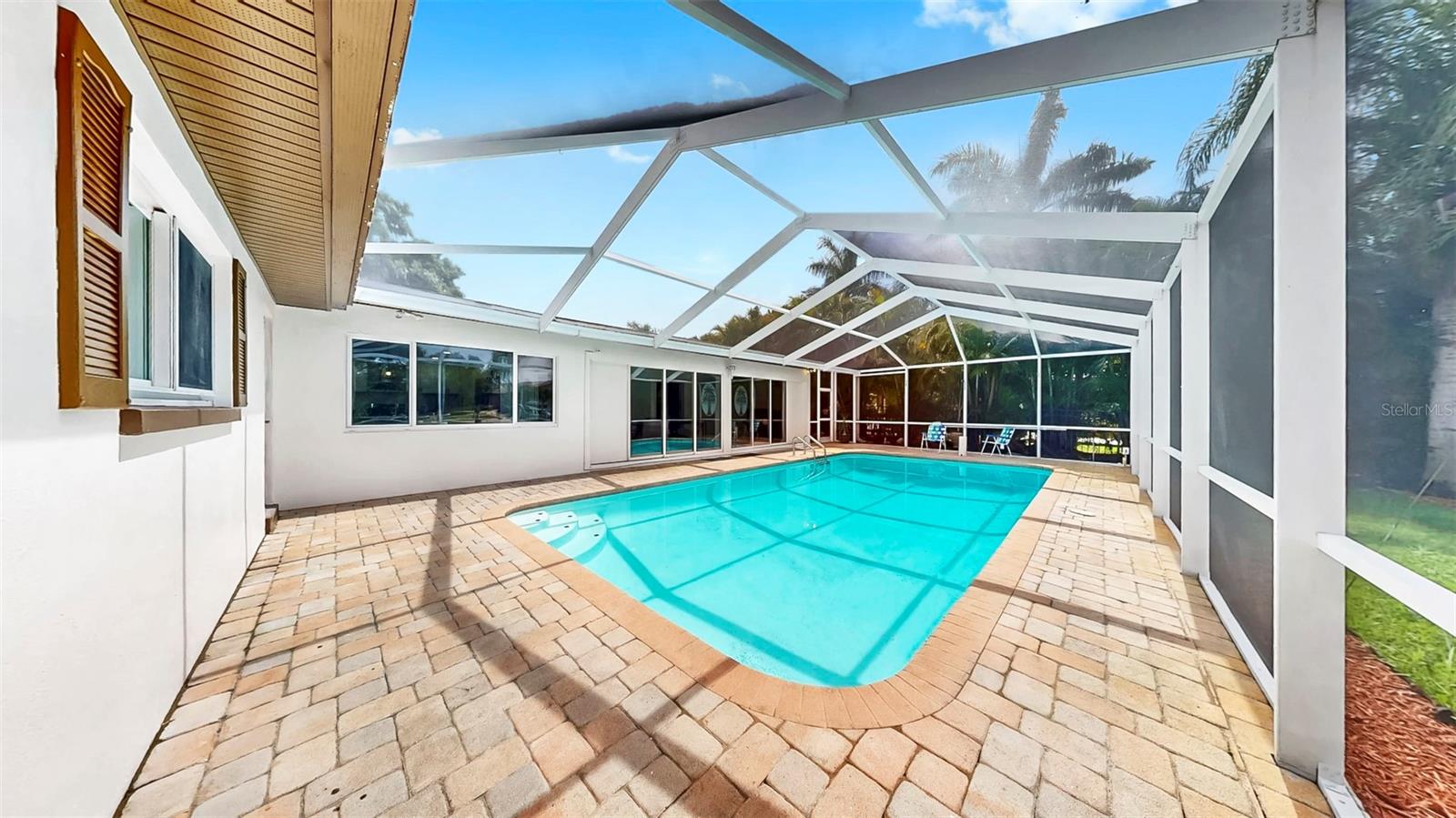 Awwwmazing pavered, screened-in pool area with waterfront views!