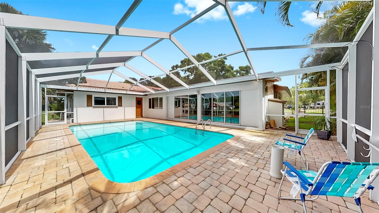 Awwwmazing pavered, screened-in pool area with waterfront views!