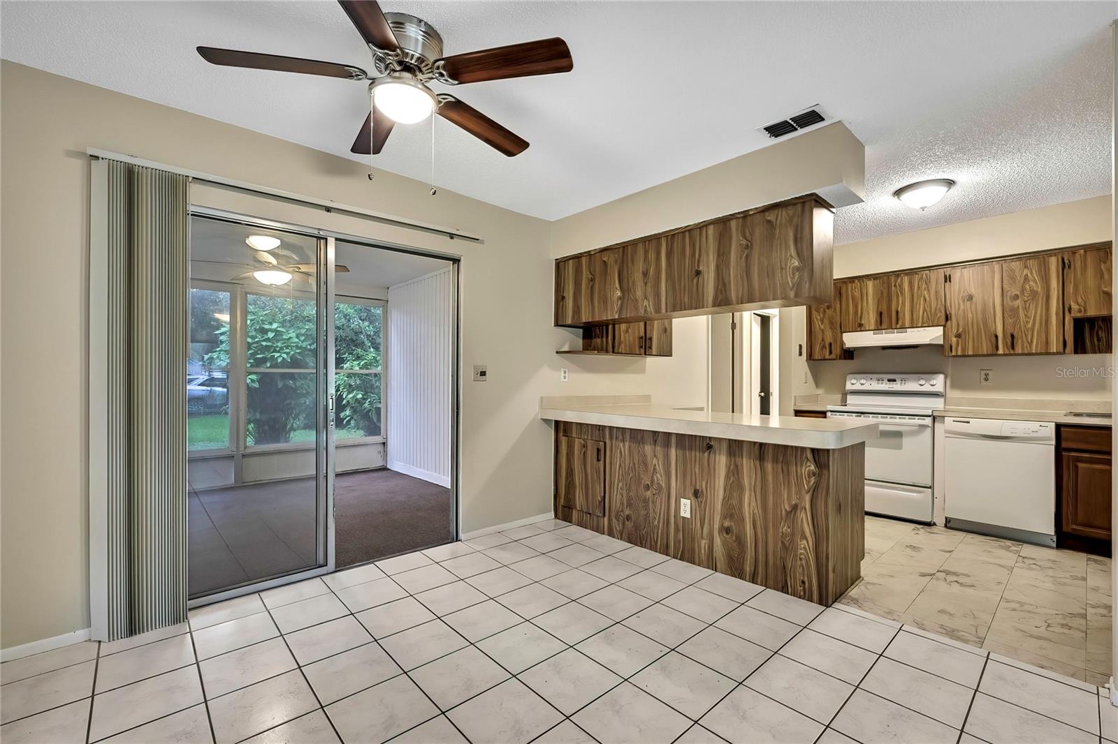 Dining area with view of screened porch and kitchen