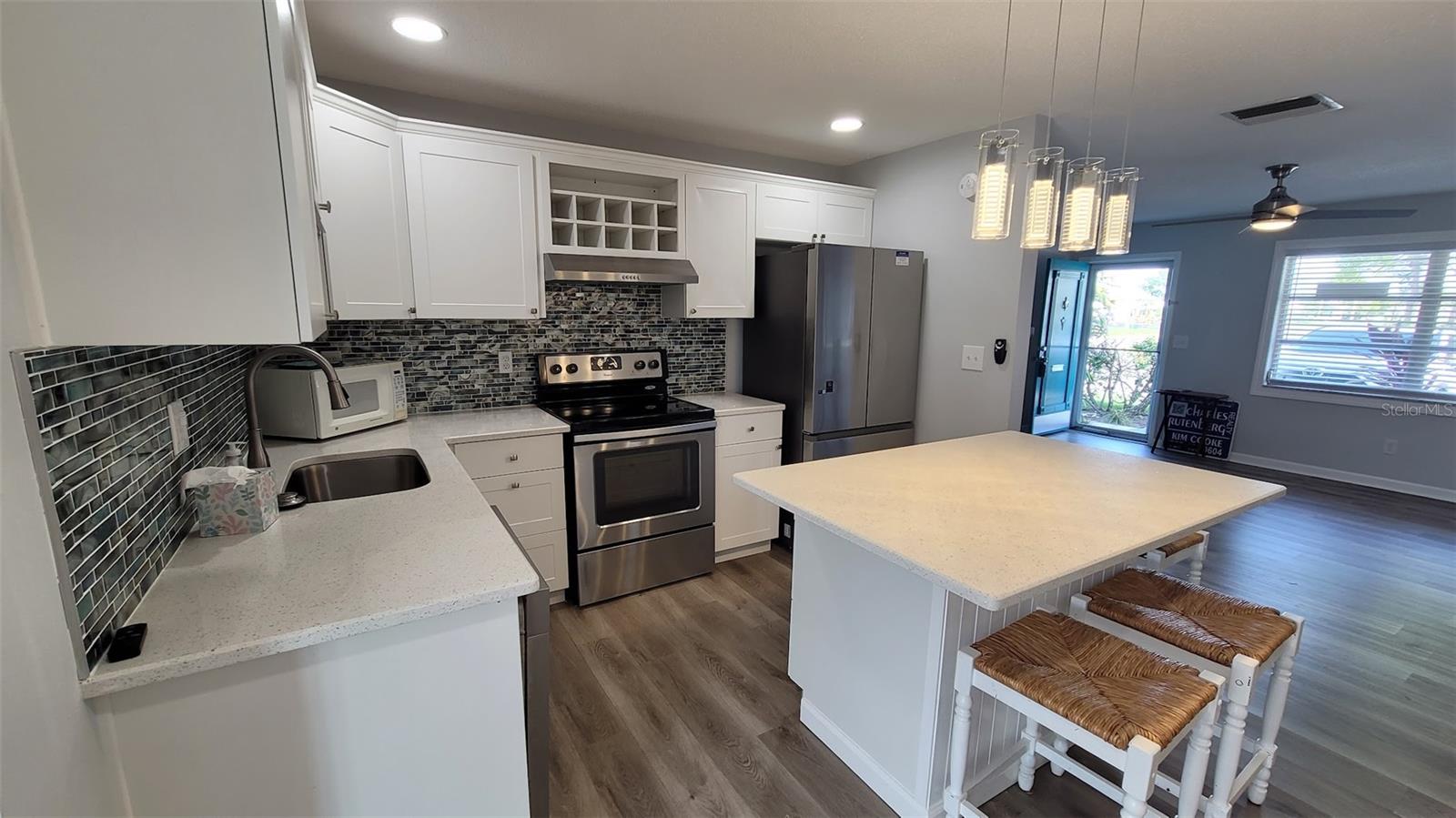 The quartz counters are beautiful and the island will be sure to please those that like to cook and bake. Imagine being able to roll out pasta or make cookies with the grands.