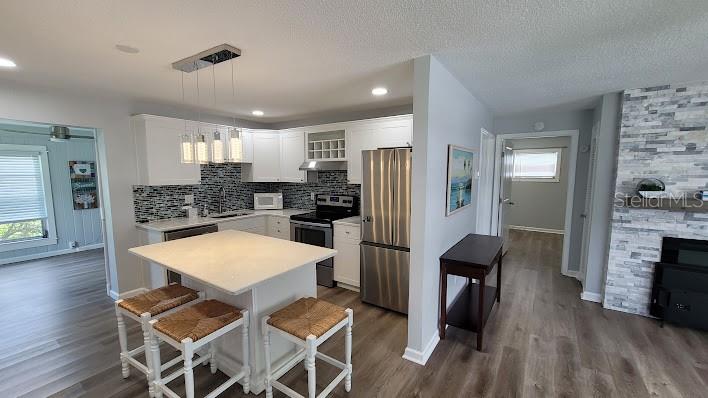 The center of the home houses a beautiful kitchen with an island. The hallway on the right leads you to the Primary Suite.