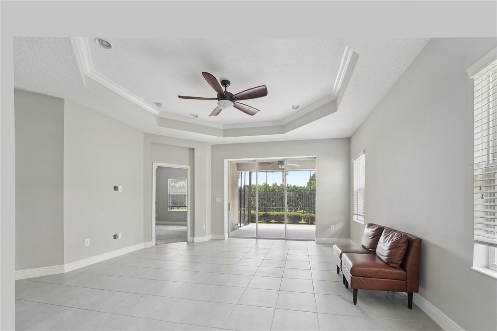 SPACIOUS FAMILY ROOM WITH DOOR LEADING TO PRIMARY SUITE