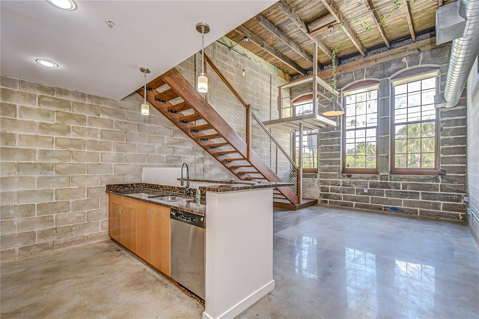 Soaring ceilings, polished concrete floors, and floating wood stairs create a dramatic look!