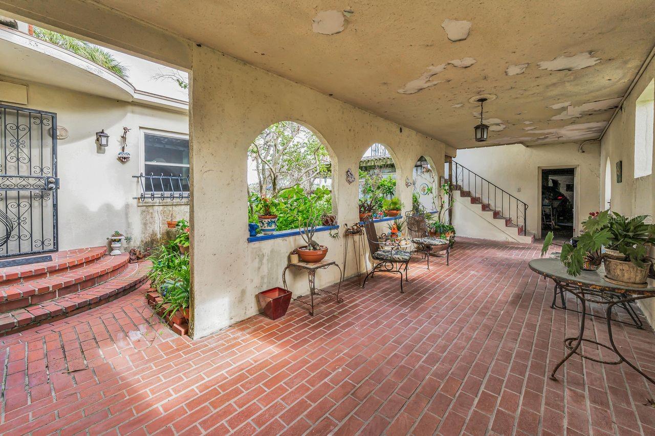 Courtyard with kitchen entrance on left and garage to the right.
