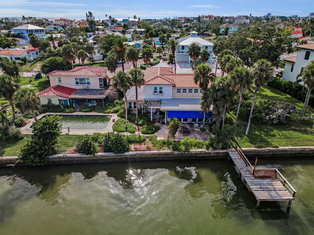 Complete view of the rear of the property. Guest suite is above garage and just off the pool to left, main home with large size yard and dock to the right. Joined together by an amazing breezeway in the front of the home.