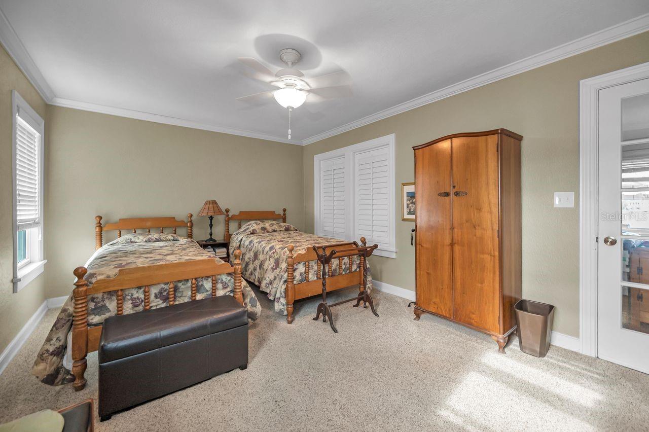 Second bedroom upstairs with enclosed porch to view the water through doorway on right.
