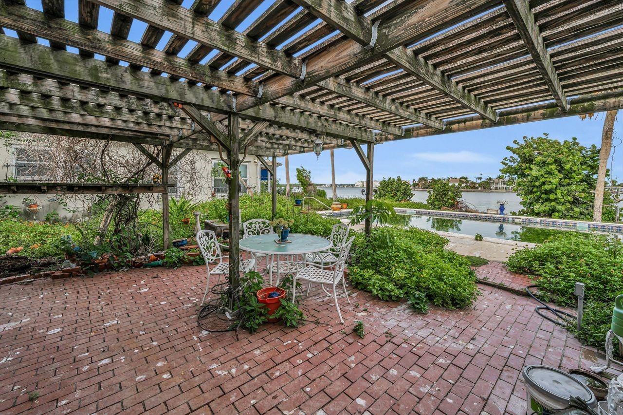 Pergola covered outdoor seating area overlooking the pool and the Intracoastal Waterway.
