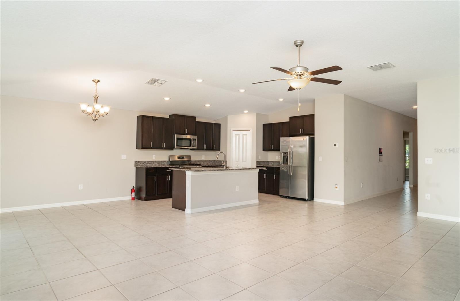 High ceilings, abundant natural light, and a CHEF’S KITCHEN with GRANITECOUNTERTOPS, STAINLESS STEEL APPLIANCES, a large KITCHEN ISLAND, and a WALK-IN PANTRY make it perfect for entertaining.