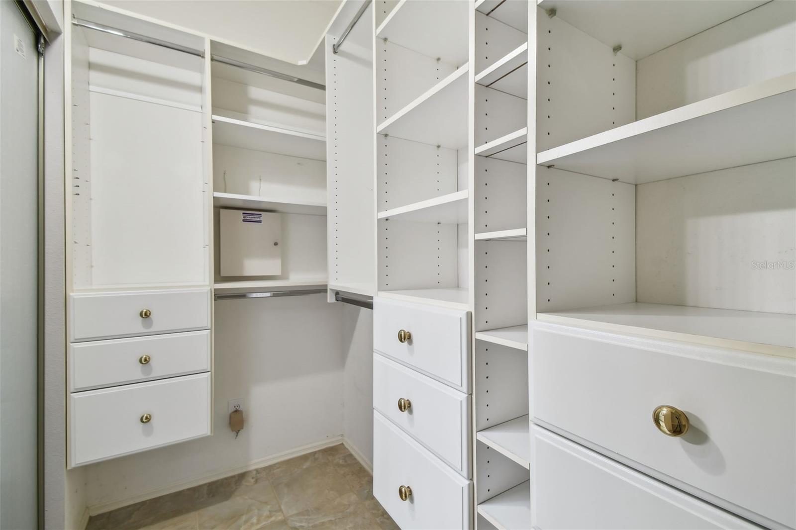 Walk in closet with custom drawers shelves racks and baskets