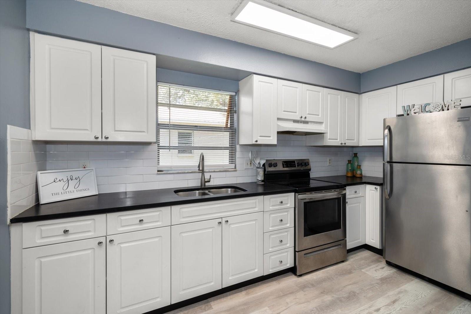 Kitchen with new cabinets, appliances and stone counter.
