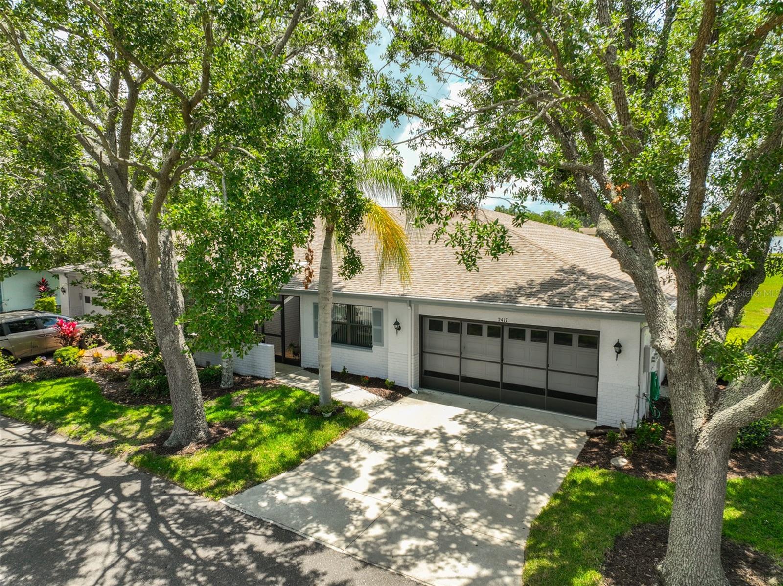 Tranquility with shade trees, landscaping and a quiet street.  Notice the garage has a screen cover.