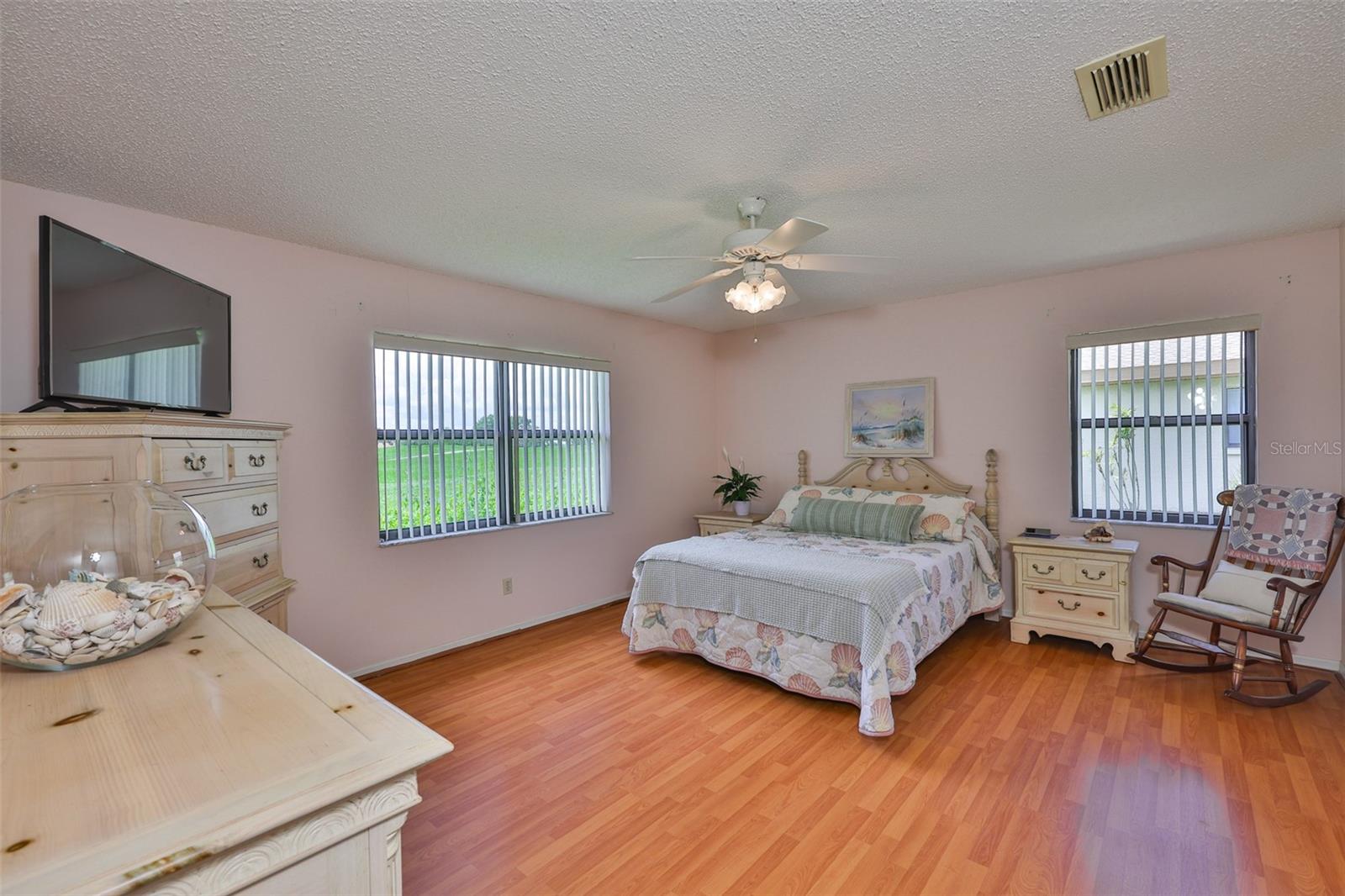 Primary bedroom has lovely laminate flooring, large windows and lots of space for large furniture.