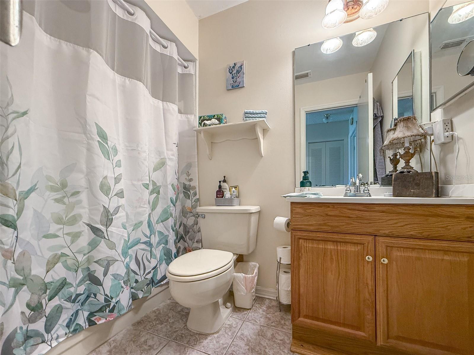 Guest bathroom is sparkling clean with a tub/shower combo.