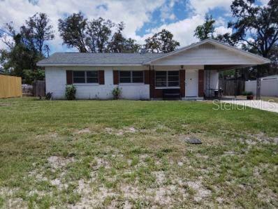 Front exterior view of the home with covered carport and spacious front yard.