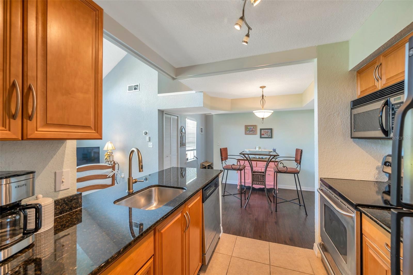 the kitchen features granite counters, stainless steel appliances, disposal and attractive wood cabinetry