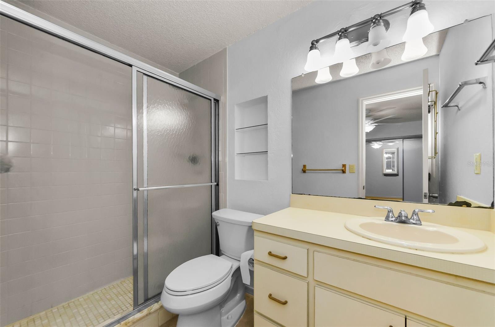 Primary barthroom with newer Kohler toilet and fully tiled shower.