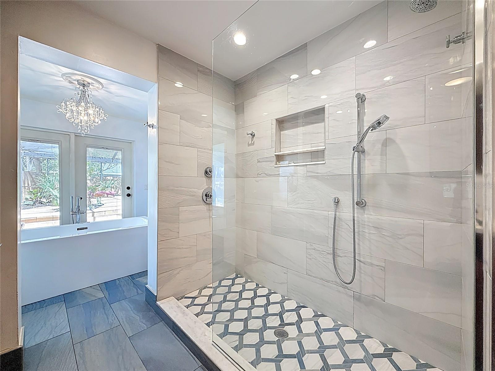 Walk-in shower with Dual shower heads, custom tile, and frameless glass surround