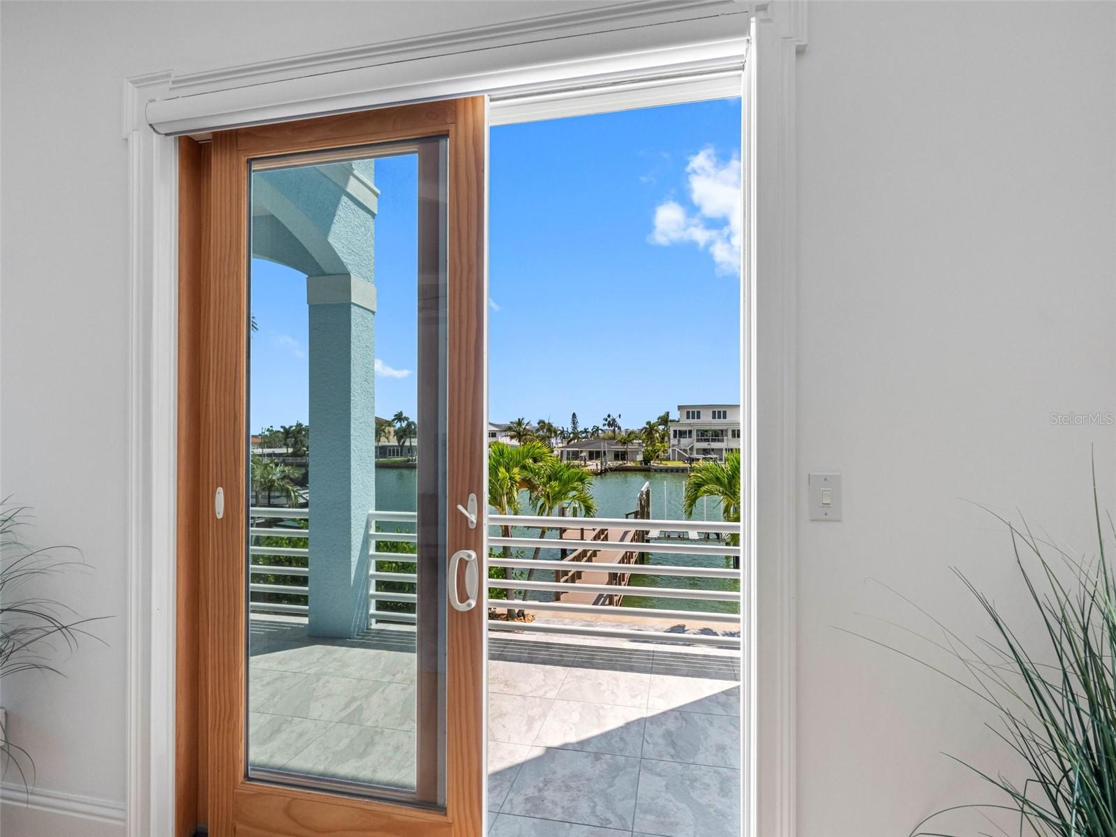 Impact doors lead to covered balcony.
