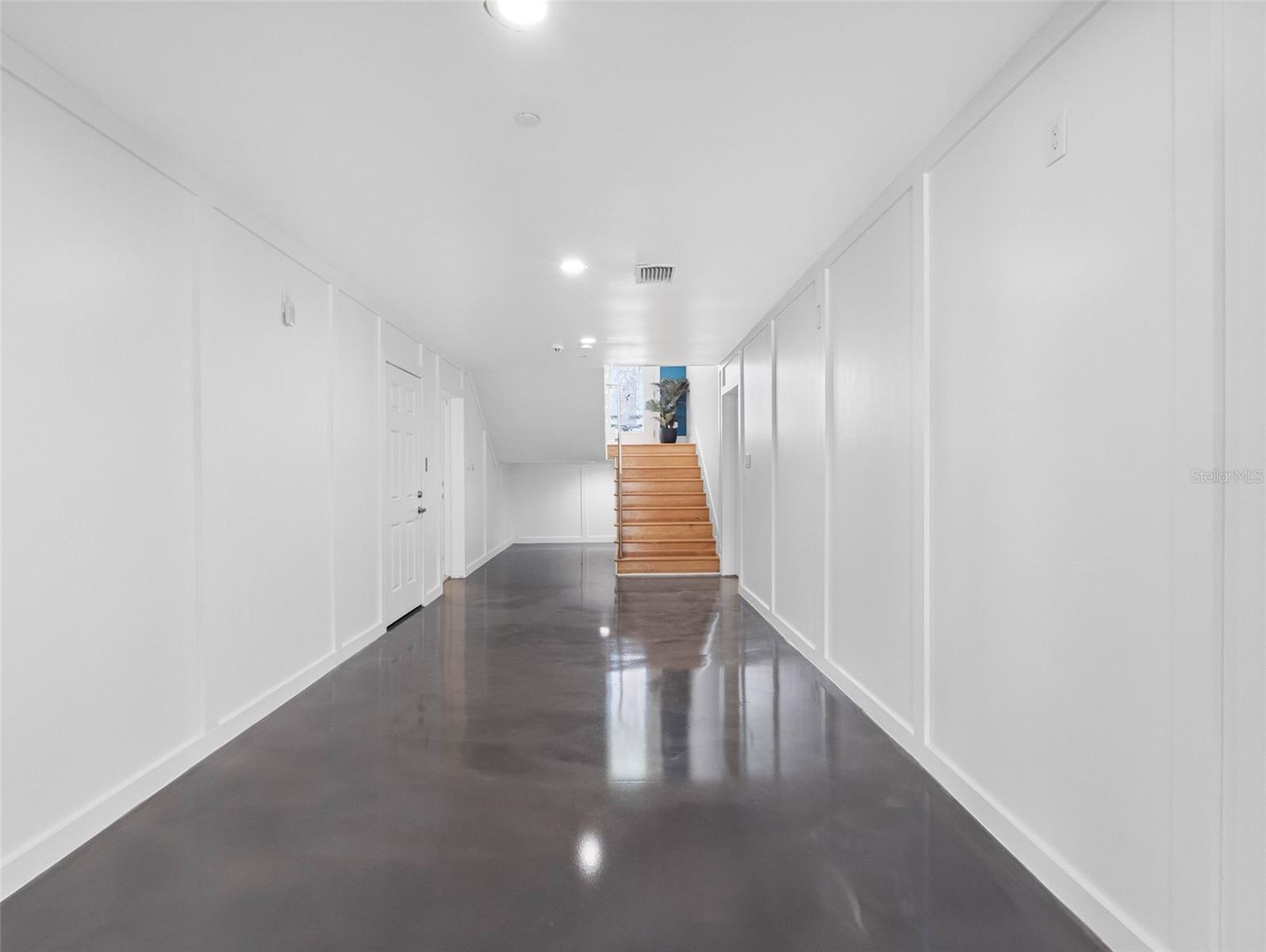 Gleaming epoxy floor opens from both garages.  Leads to stairs or elevator to upper floors and large bonus room that run the width of the house.
