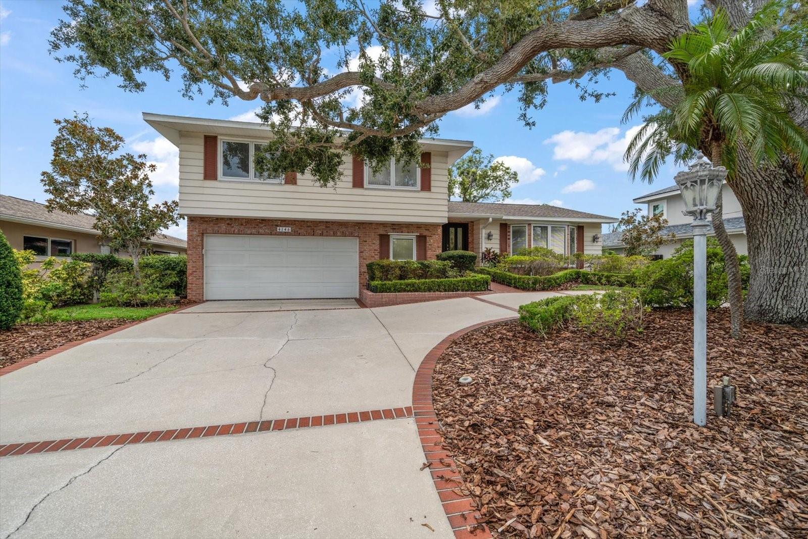 large 2 car garage with circle driveway and majestic oak