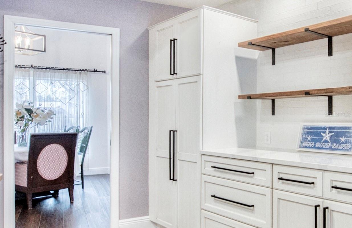 The kitchen, complete with a built-in pantry, flows directly into the dining room—making meal prep and serving effortless.
