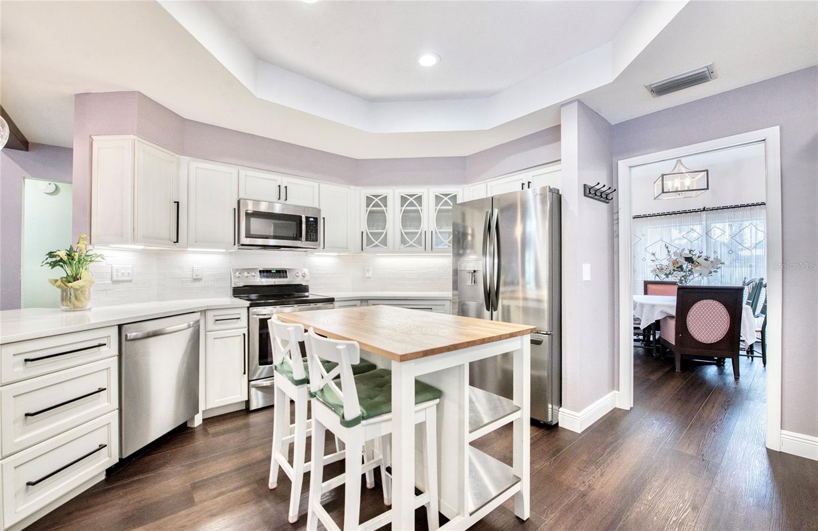 Beautifully updated kitchen offers a peninsula bar and a versatile mobile island—both with seating—creating a perfect flow into the spacious Great Room. The adjacent dining area is ideally situated for effortless entertaining