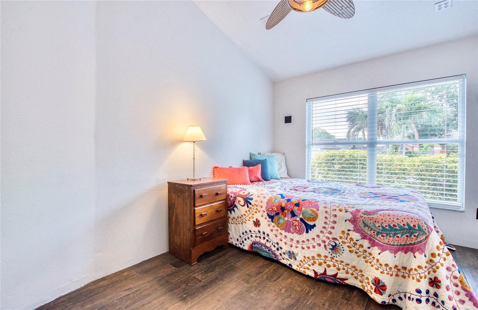 4th bedroom with vaulted ceilings is filled with natural light and is accessed through a hidden doorway, cleverly concealed behind a built-in bookshelf.