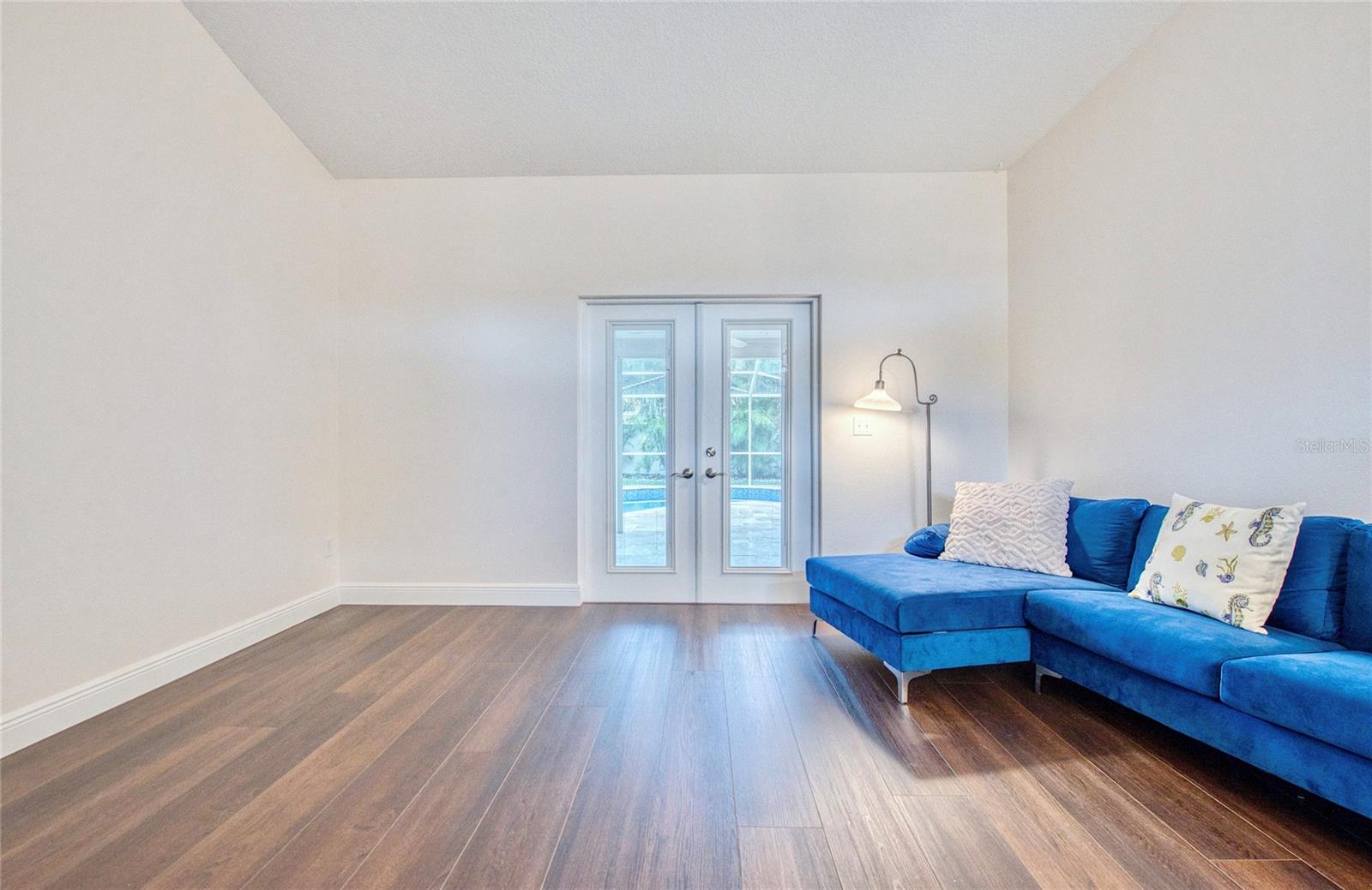Living room welcomes you with serene pool views through elegant French doors and flows seamlessly into a dedicated dining area—ideal for both everyday living and entertaining.