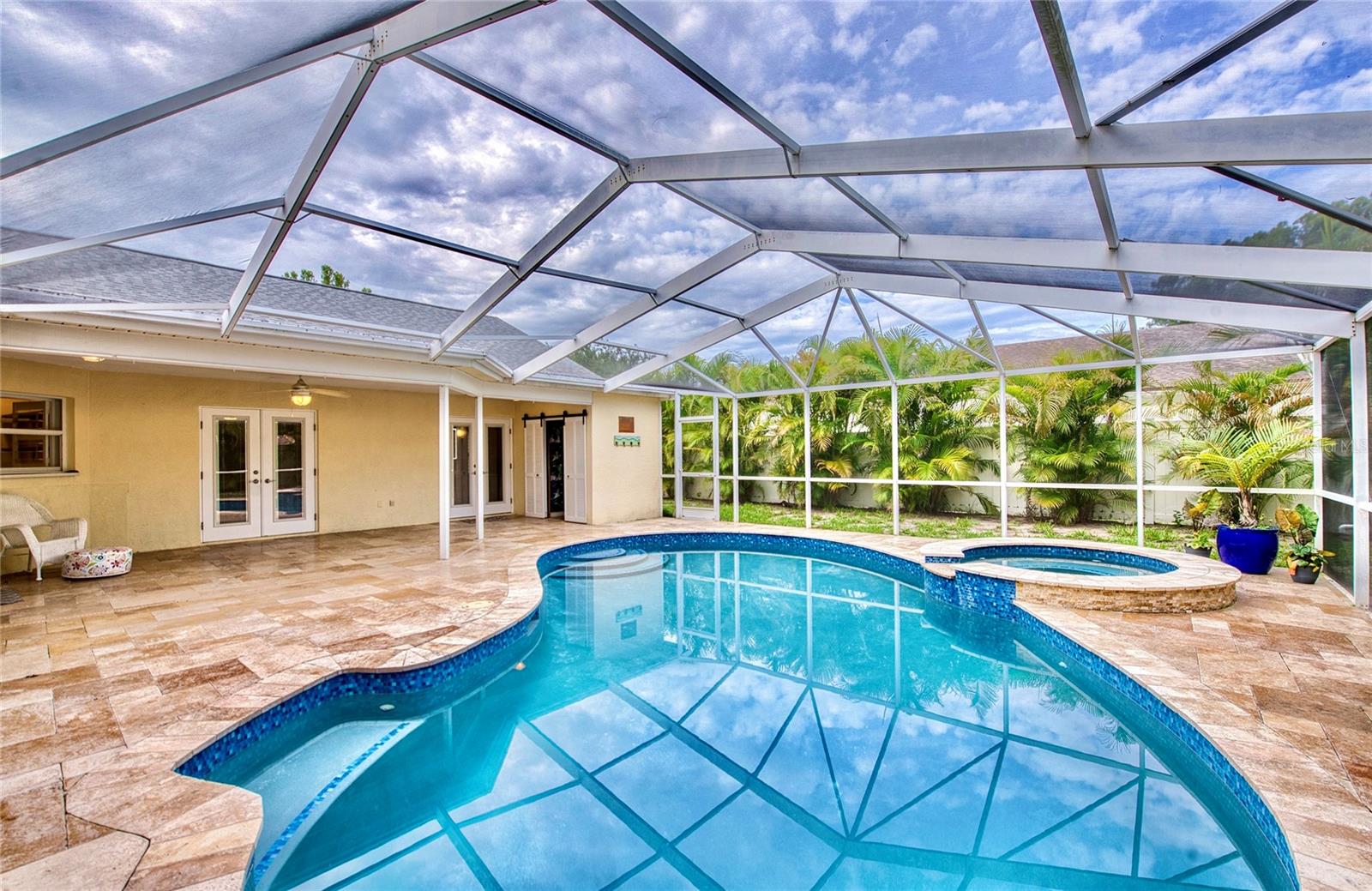 A relaxing spa adjoins the freeform pool, which features a built-in bench—perfect for lounging and enjoying the Florida sunshine.