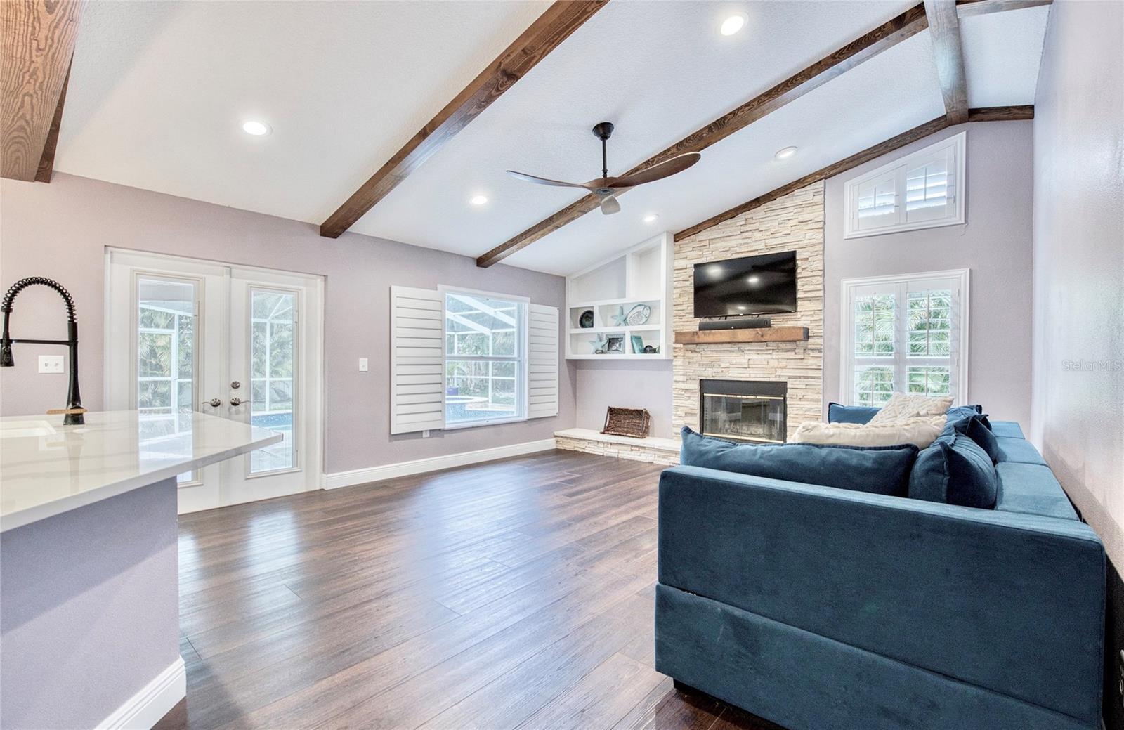French doors off the Kitchen/Great Room open to the pool lanai, creating a seamless indoor-outdoor living experience.