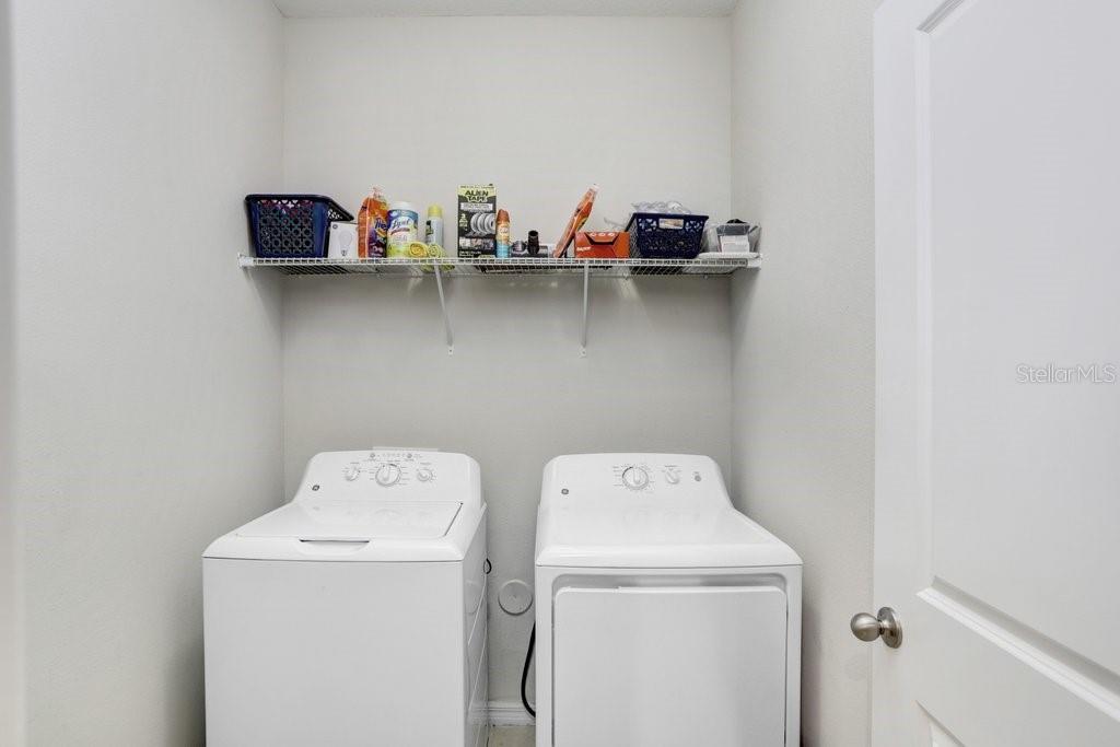 indoor laundry room with storage shelf