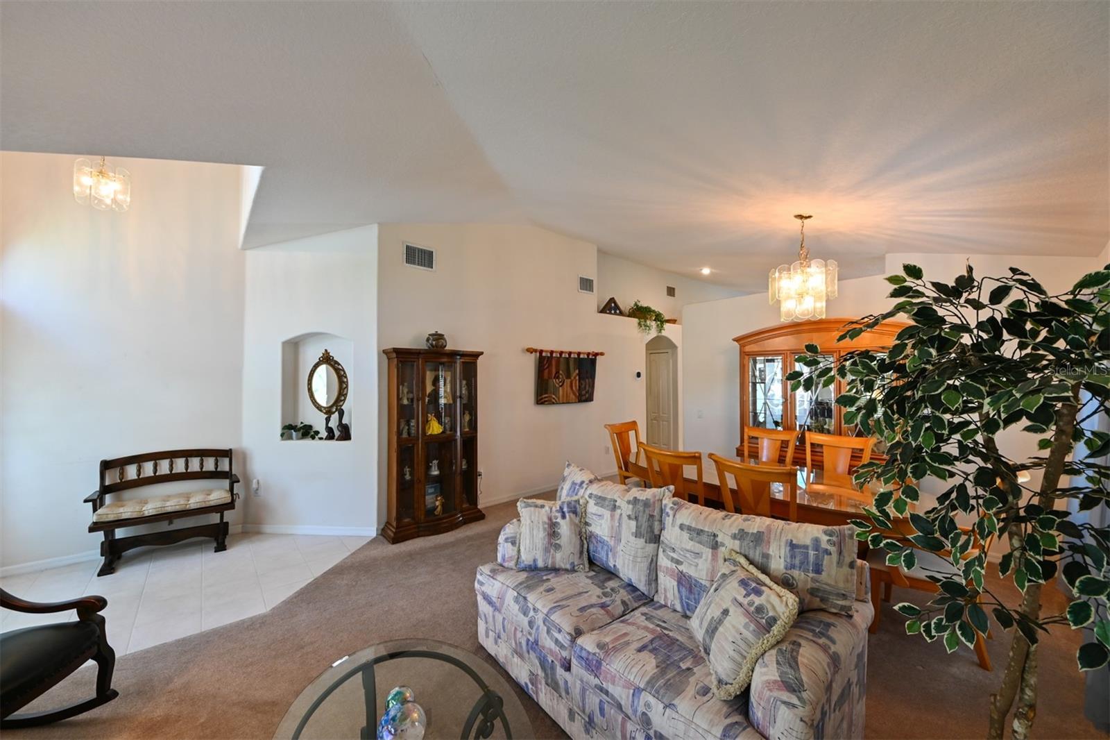View of Living and Dining Room. The entrance is to the left and the kitchen is on the other side of the dining area. The arched doorway seen in the photo leads you to the laundry, main bathroom and the two bedrooms.