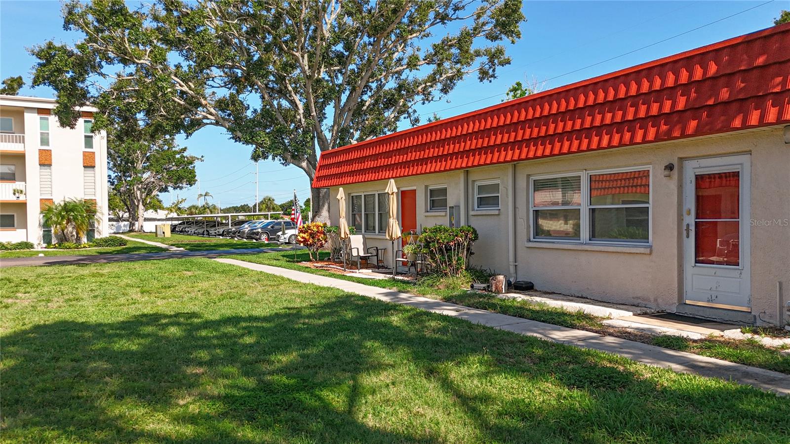 The back door leads to a green space shaded by oak trees.