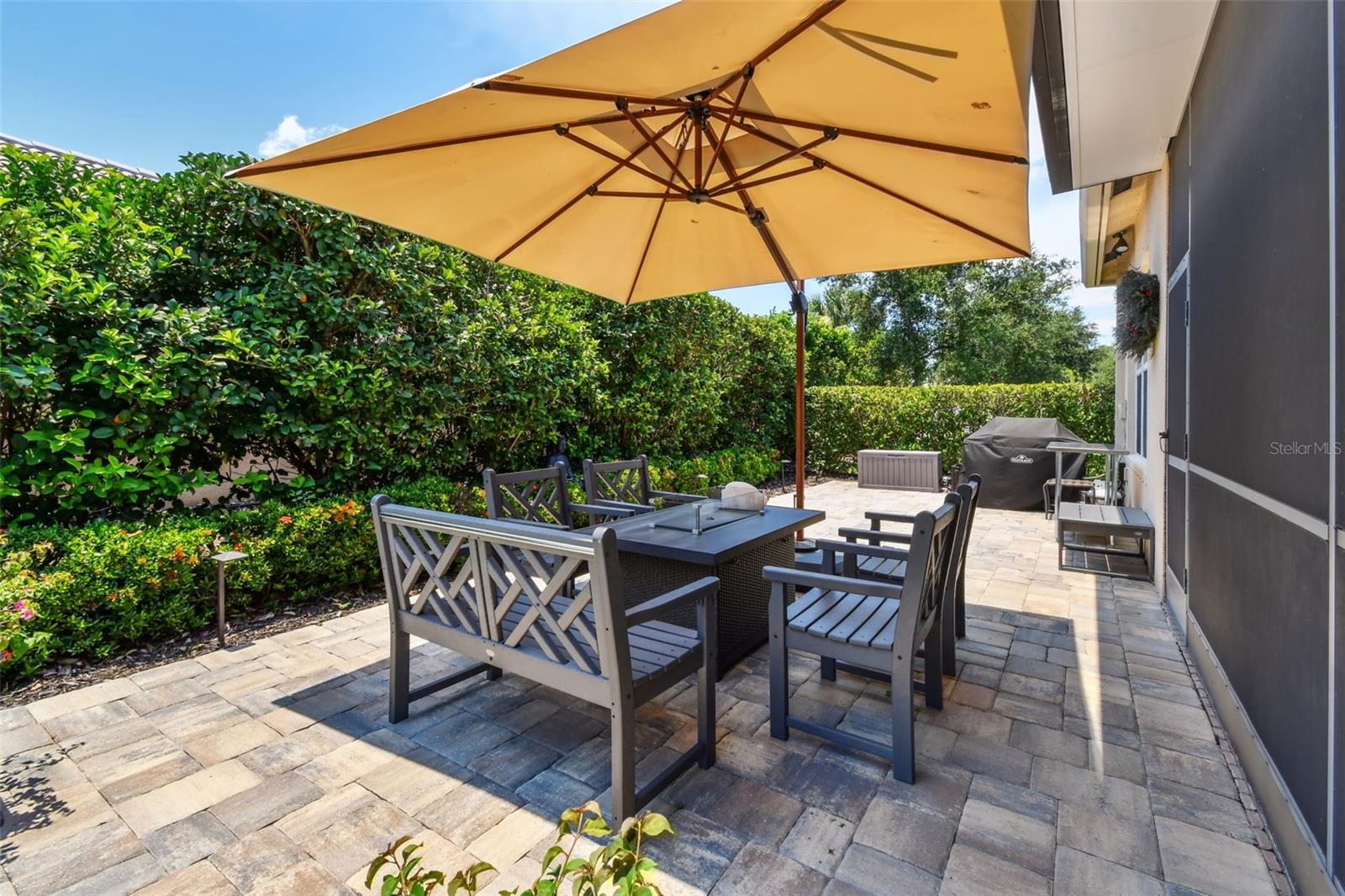 This open air patio is landscaped to provide privacy and contains landscape lighting that adds a glowing ambiance to the outdoor space in the evening.