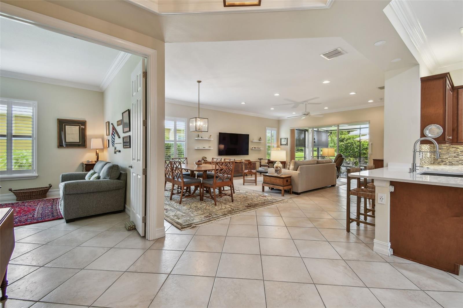 Wide open floor plan with tile, fresh paint, plantation shutters, and crown molding throughout