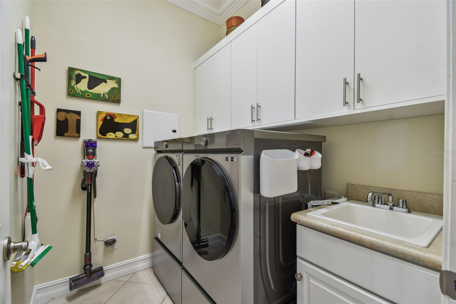 Laundry room with NEW washer and dryer, utility sink and cabinets.