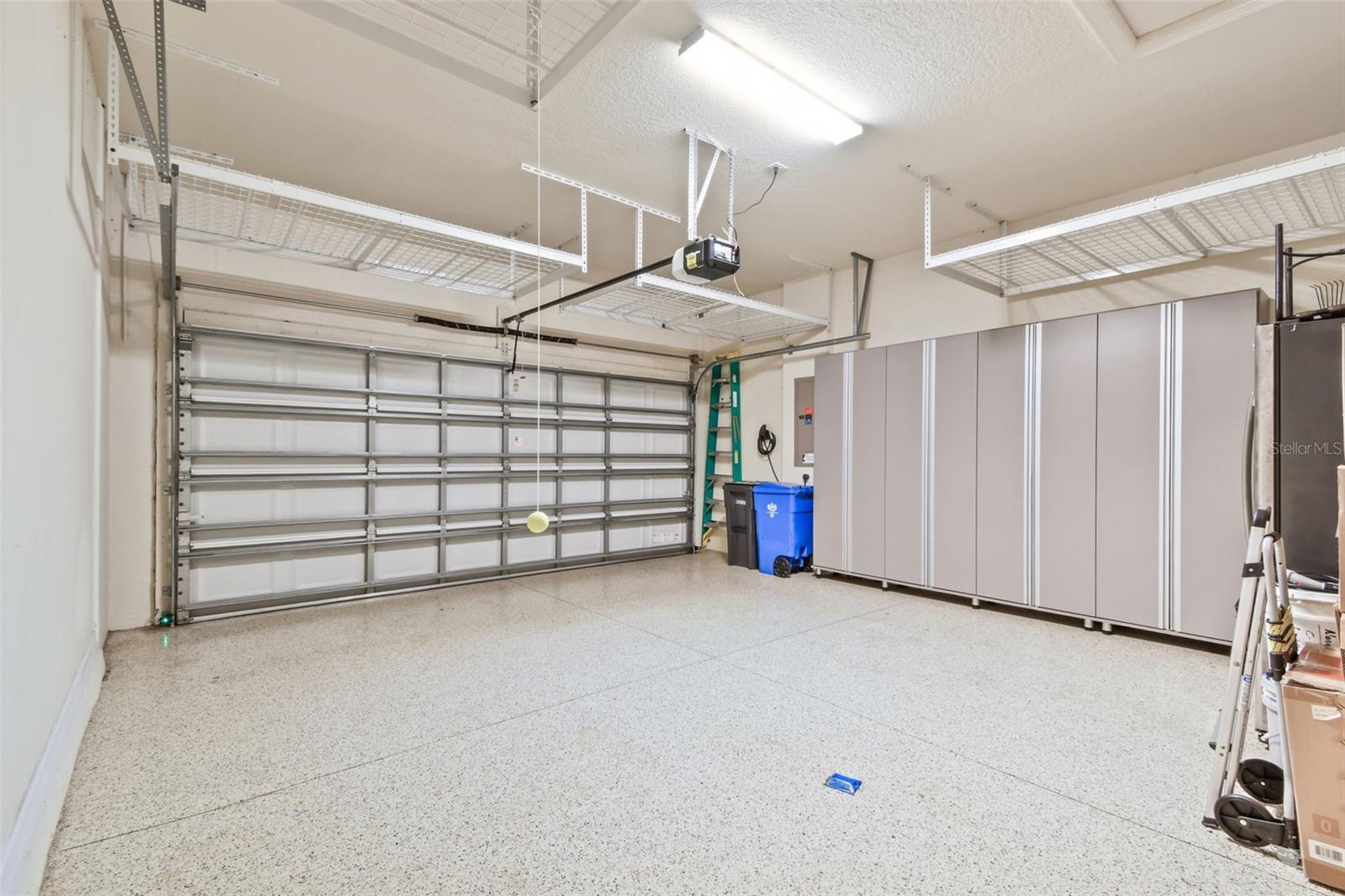 Garage with NEW soft close door wall storage, overhead storage racks, NEW Hot water tank (2024) NEW epoxy flooring, NEW EV 220 outlet for car and golf cart charger