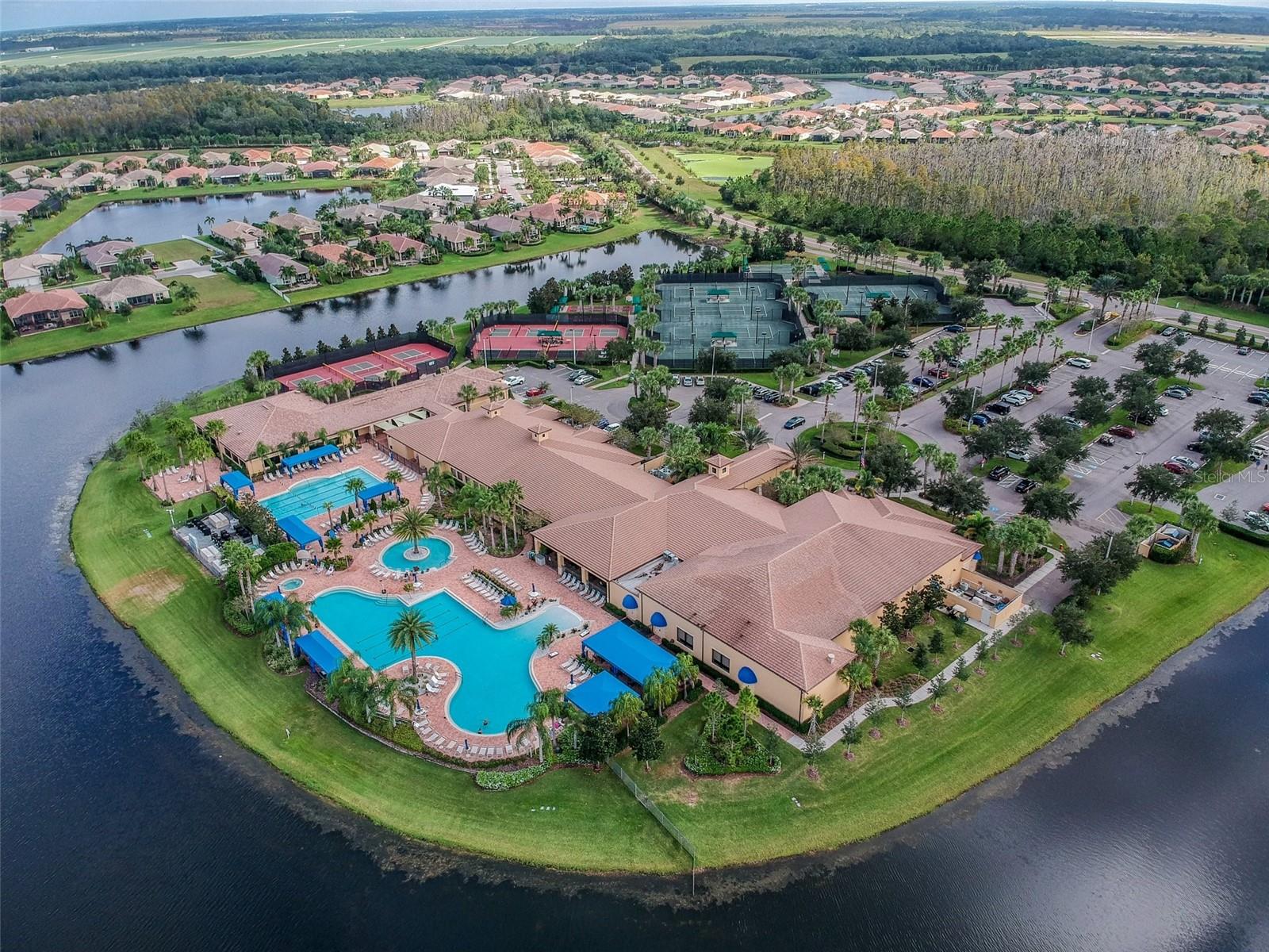 Aerial view of clubhouse and amenities - notice tennis, pickleball and various pools