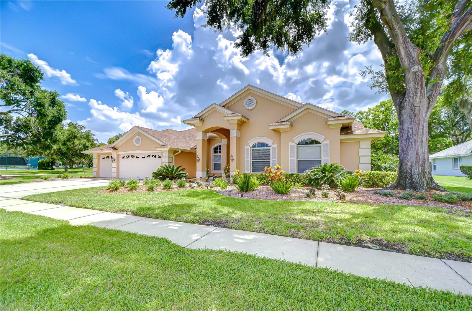 Right side view of your new home across from tennis courts and other amenities such as Pickle ball, basketball, fishing, & playground.
