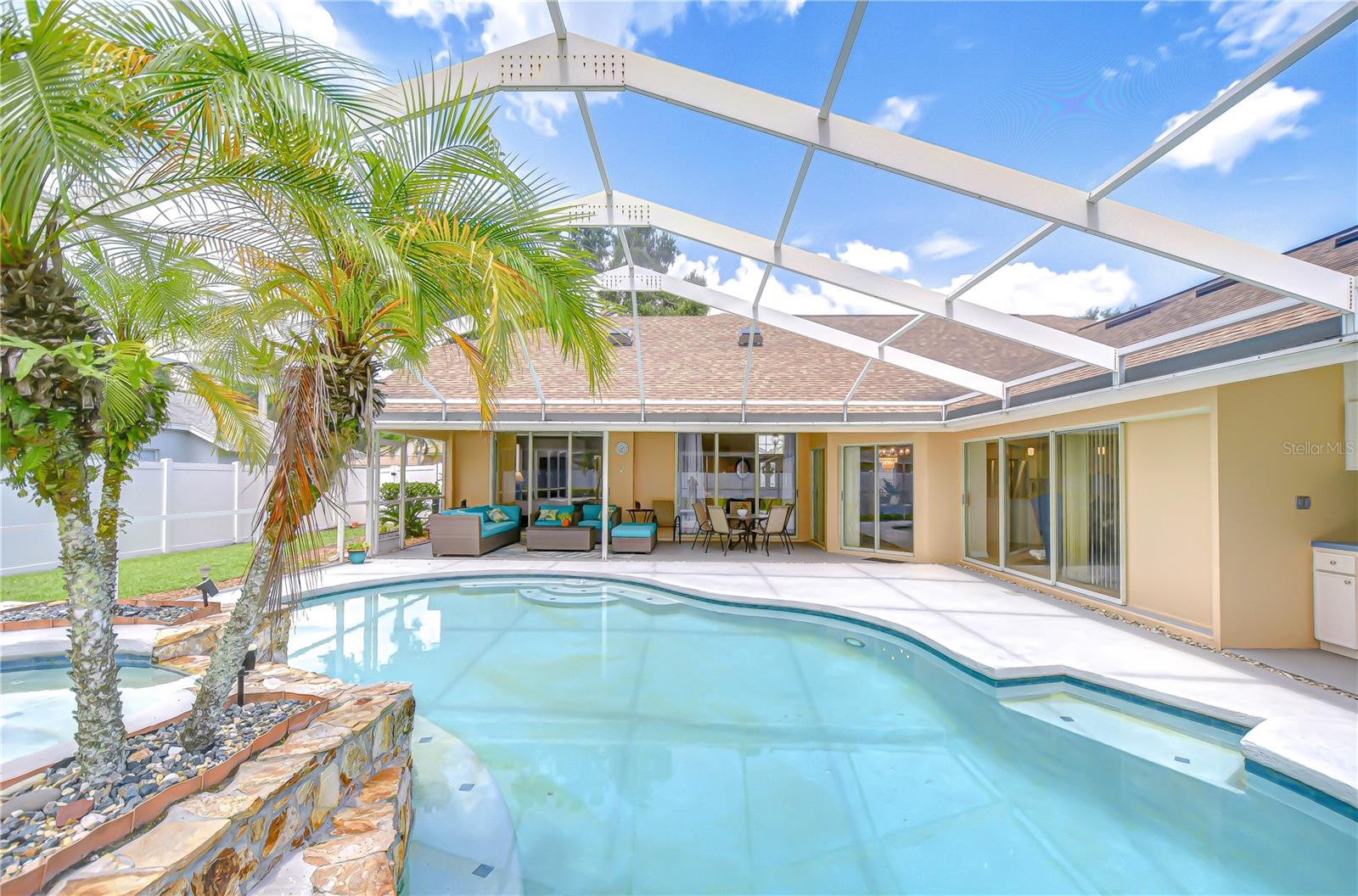 Screened in lanai with Large covered area.  Sliders in living room, primary bedroom, and family room open up to lanai and tuck away for parties.