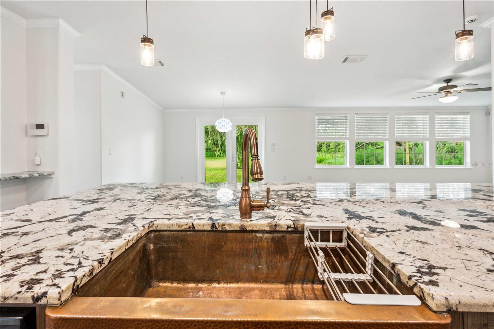 Kitchen features a custom copper sink paired with a matching copper-finish faucet, offering both timeless style and functional elegance.