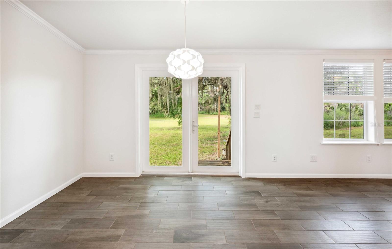 Dining area features elegant French doors that open to a spacious backyard paradise.