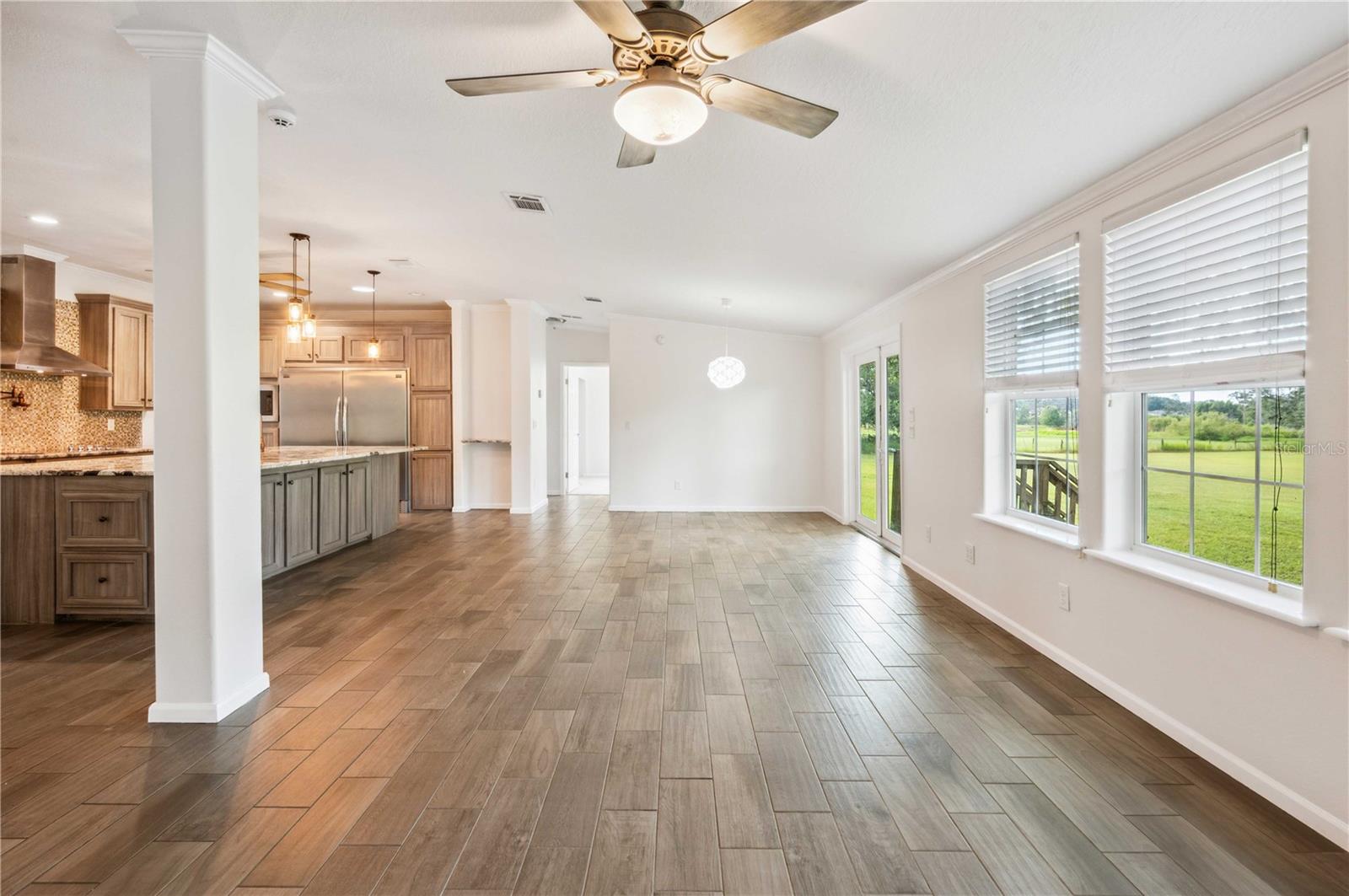 Spacious living room with an open layout seamlessly connected to the dining area, kitchen, and foyer.