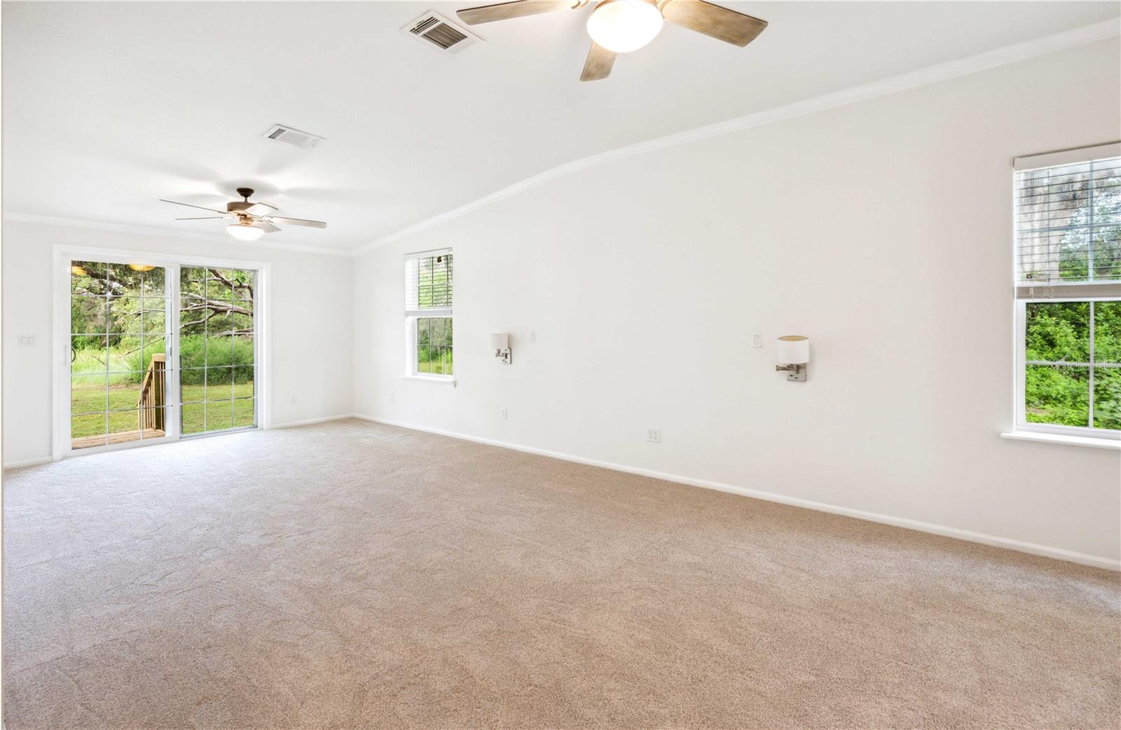 Primary bedroom offers new carpet, double ceiling fans, and sliding doors leading to your backyard oasis.