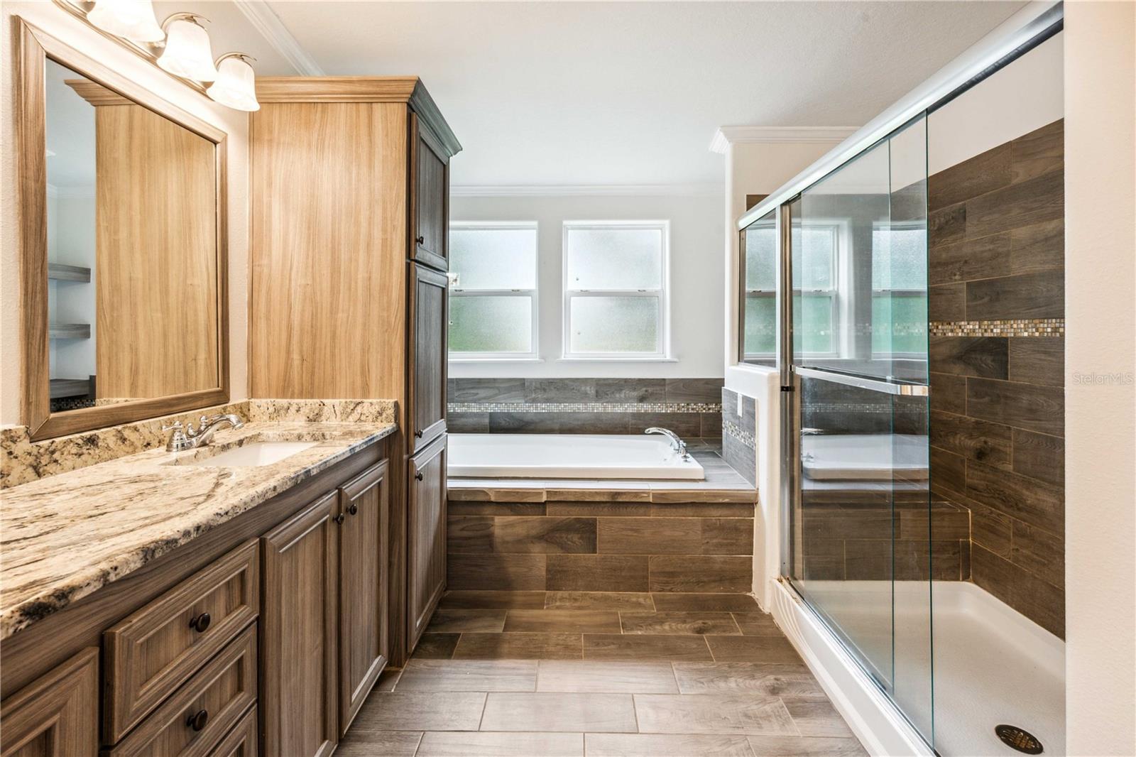 Relax in the primary retreat complete with a step-in shower, double vanity, and luxurious deep bathtub.