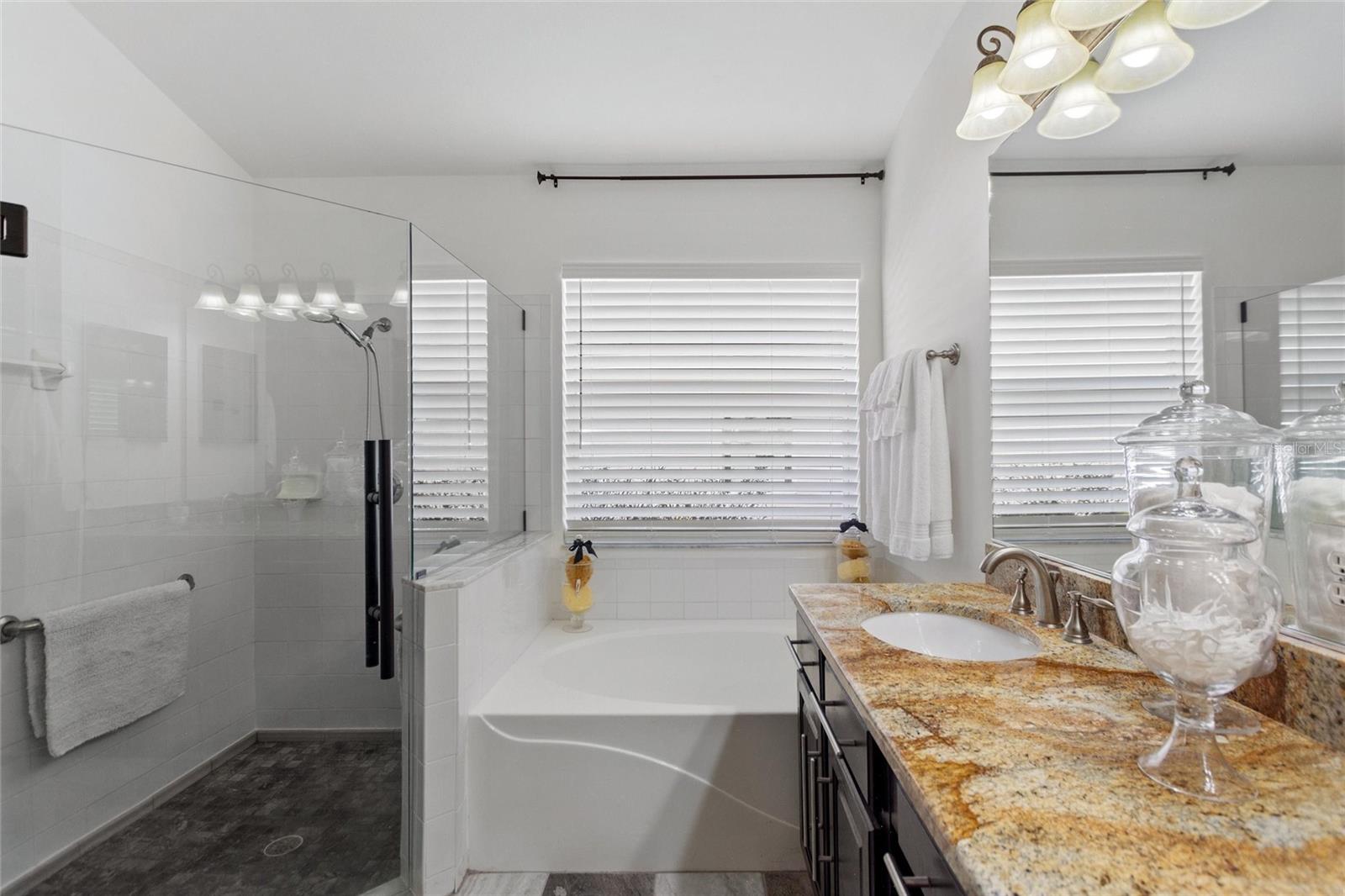 A huge shower and large garden tub accentuate the bathroom.  Notice the large window allowing natural light into the room.