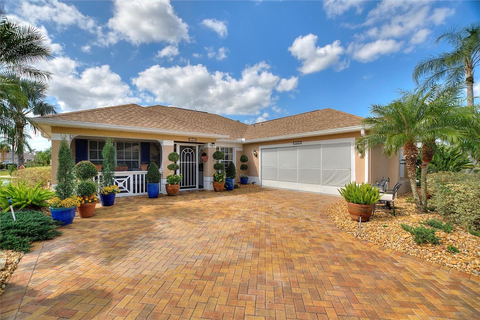 Wide custom pavered driveway, front porch and with lovely screens for the garage to ensure privacy.