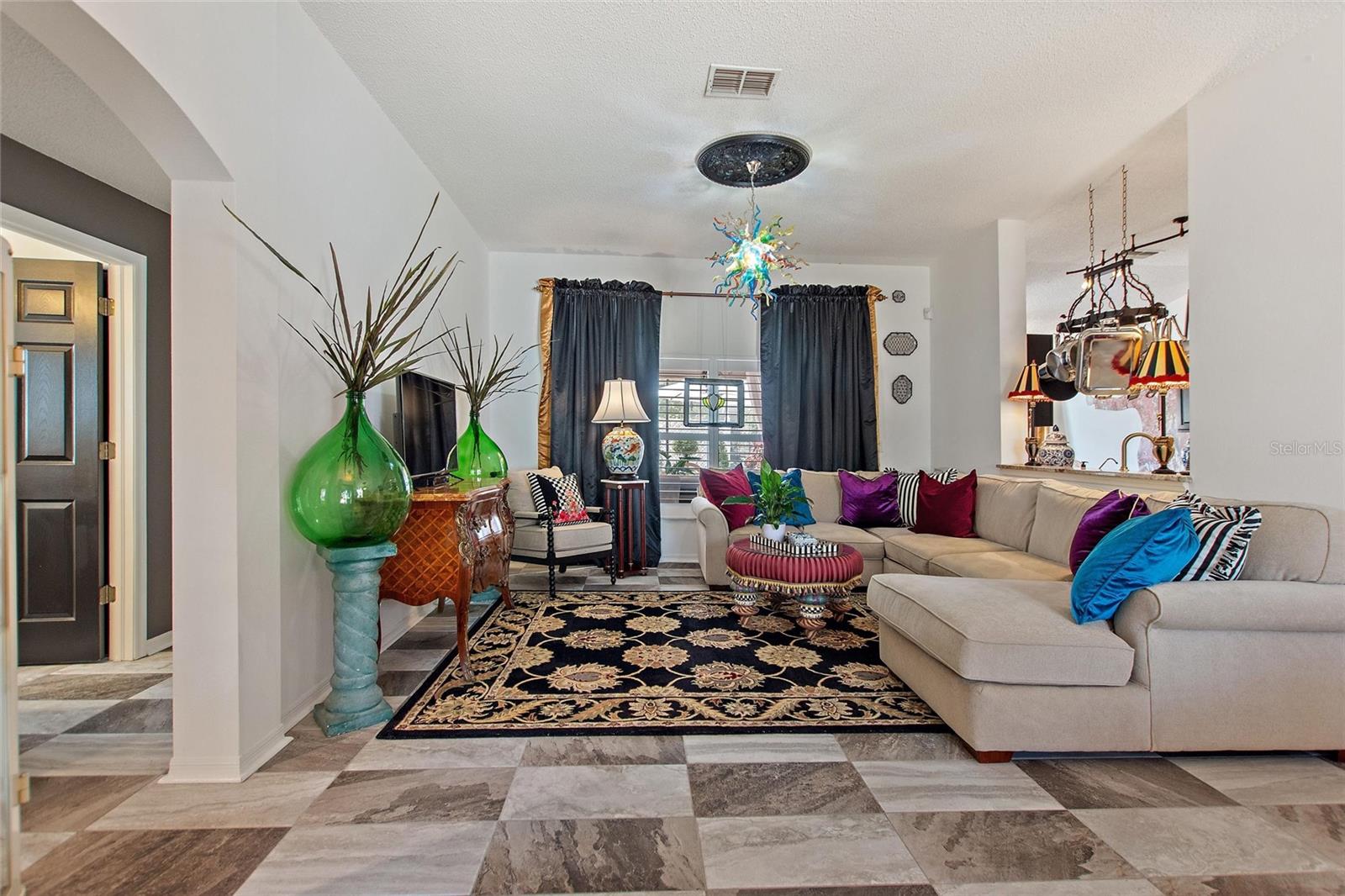 Walk into the large living area with sliding glass doors which lead onto the lanai.  Notice the floors and custom lighting.
